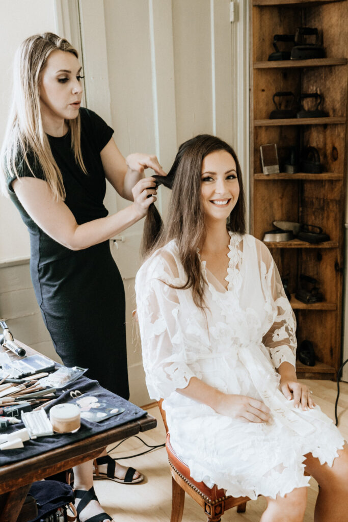 bride getting hair done during getting ready