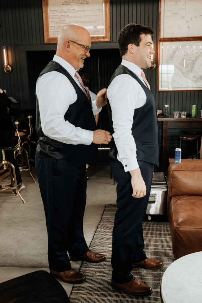 grooms father helping groom get ready for wedding at valley view farm