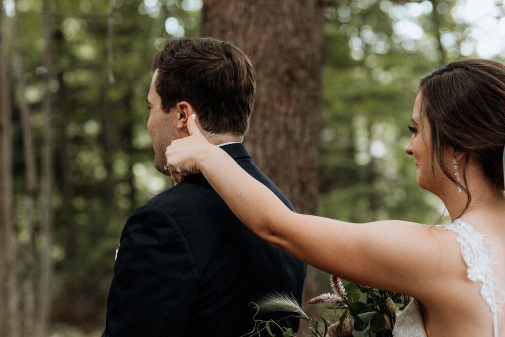 bride tickling groom's ear before first look